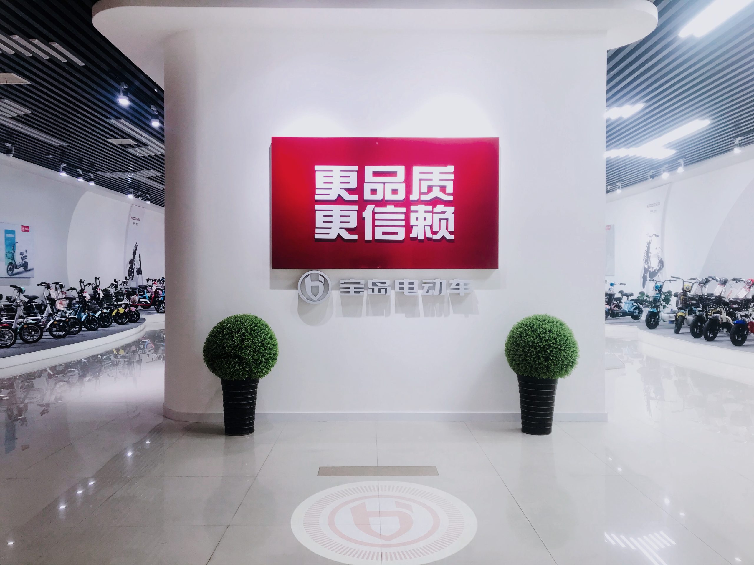 Baodao Electric Vehicle Showroom – Modern e-bike & e-motorcycle display with "Better Quality, More Trustworthy" slogan, reflecting aerospace-grade quality for global green commuting.